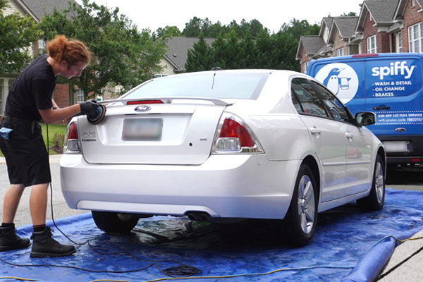 Spiffy Tech performs a hand wash on the back of a customer's car