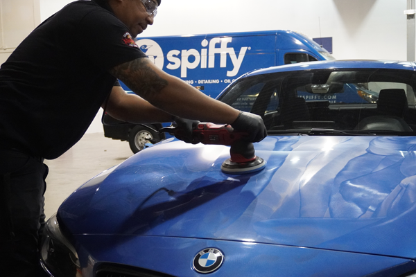Spiffy technician in the process of applying and polishing ceramic coating compound on a customer's car