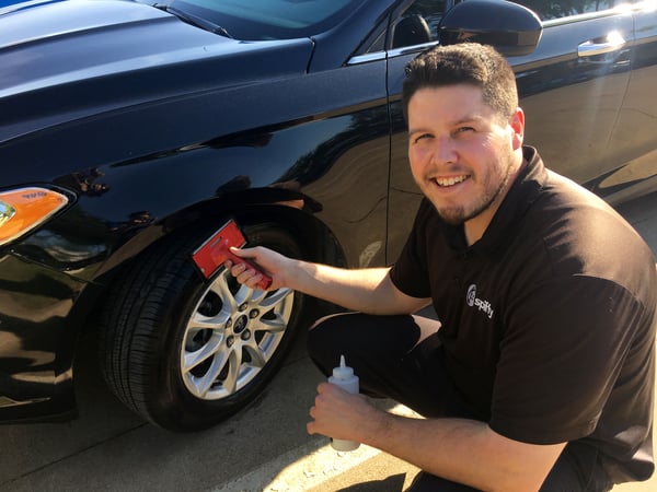 Paul showing off his smile while applying tire shine 