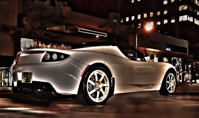 A like-new Tesla electric-powered luxury car driving in the city A like-new Tesla electric-powered luxury car driving in the city