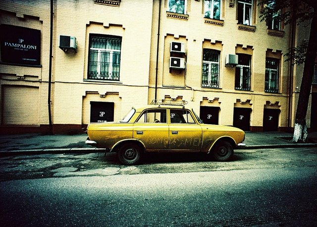 A dirty car that needs a wash parked in the street A dirty car that needs a wash parked in the street
