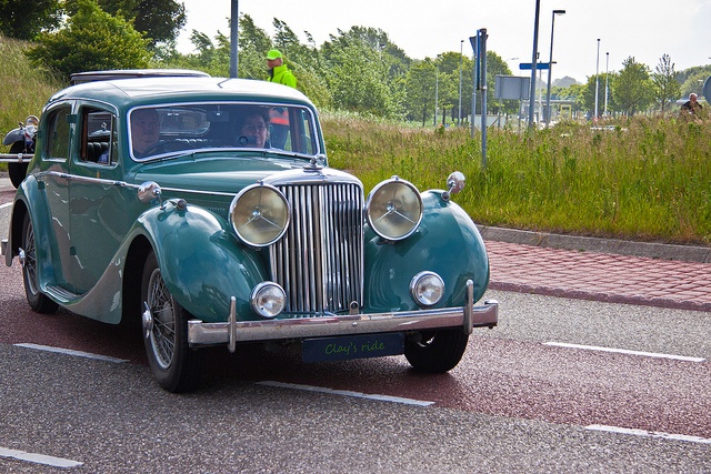 Couple riding in classic car shown cruising on the road Couple riding in classic car shown cruising on the road