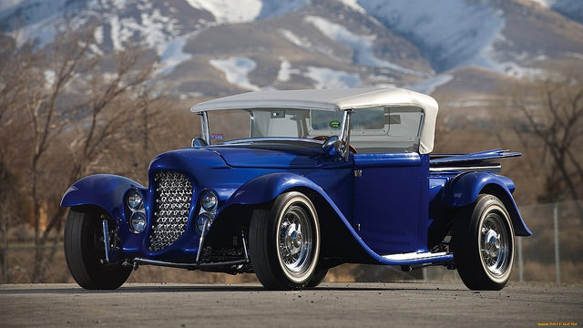 Vintage car parked in front of snowy mountains Vintage car parked in front of snowy mountains