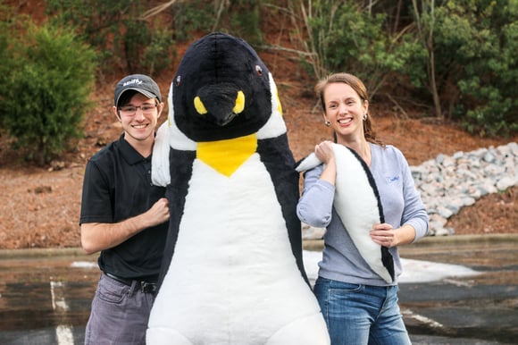 Grayson and Addison, Spiffy employees holding a giant stuffed penguin at Spiffy WWHQ