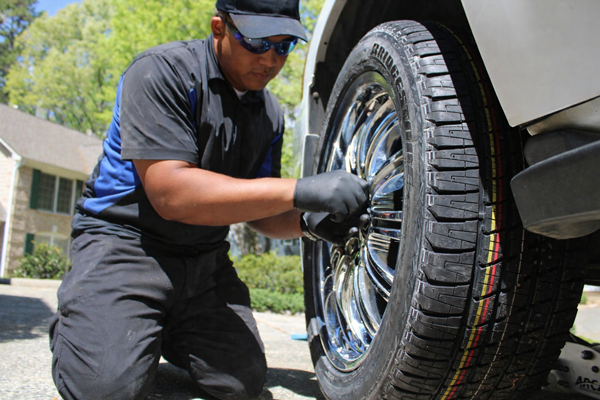 Mobile service technician working on a customers tires in the driveway