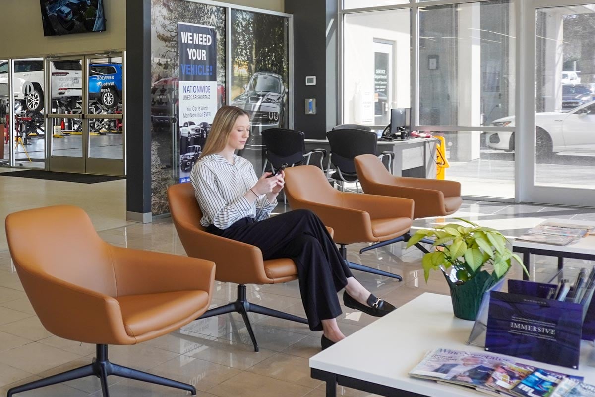 Customer waiting in a dealership lounge for her vehicle to be serviced