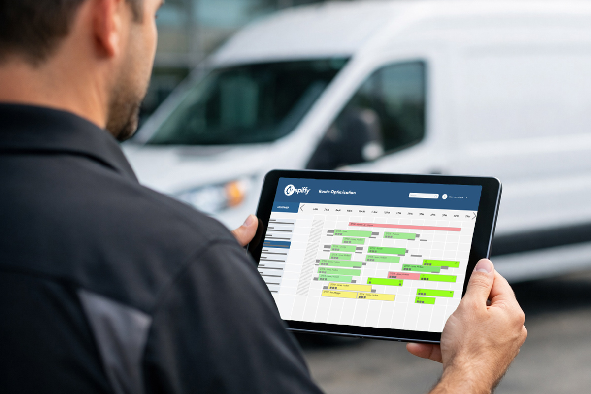 A mobile service advisor looking at a tablet that has a route optimization screen to manage mobile service routing