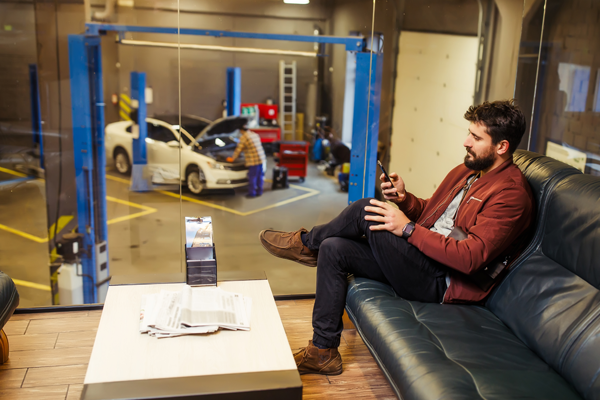 Frustrated man sitting in a car dealership, waiting for an extended period of time.