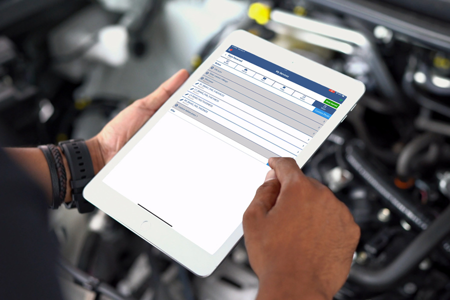 Automotive technician using the Digital Vehicle Inspection tool.